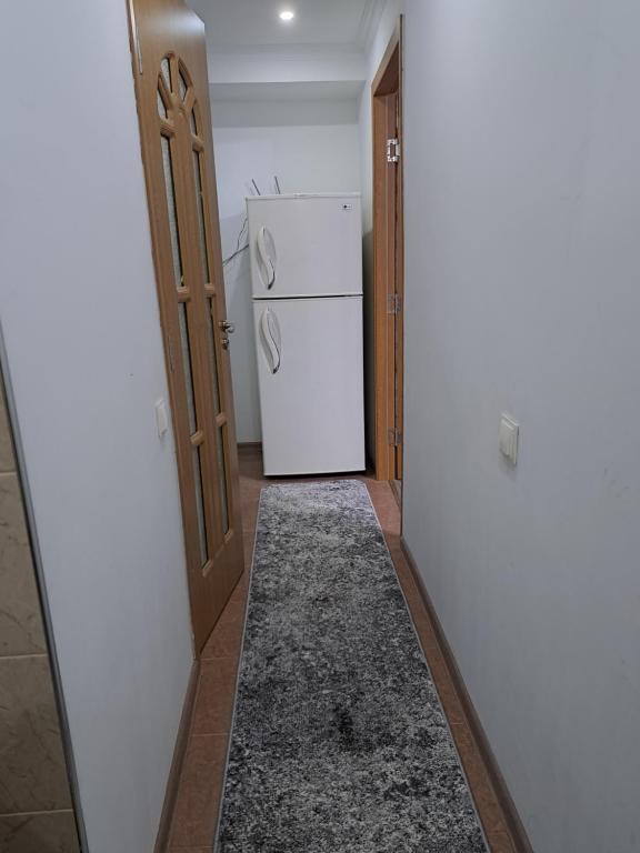 a hallway with a white refrigerator in a room at Сдаётся почасово, посуточно квартира in Edineţ