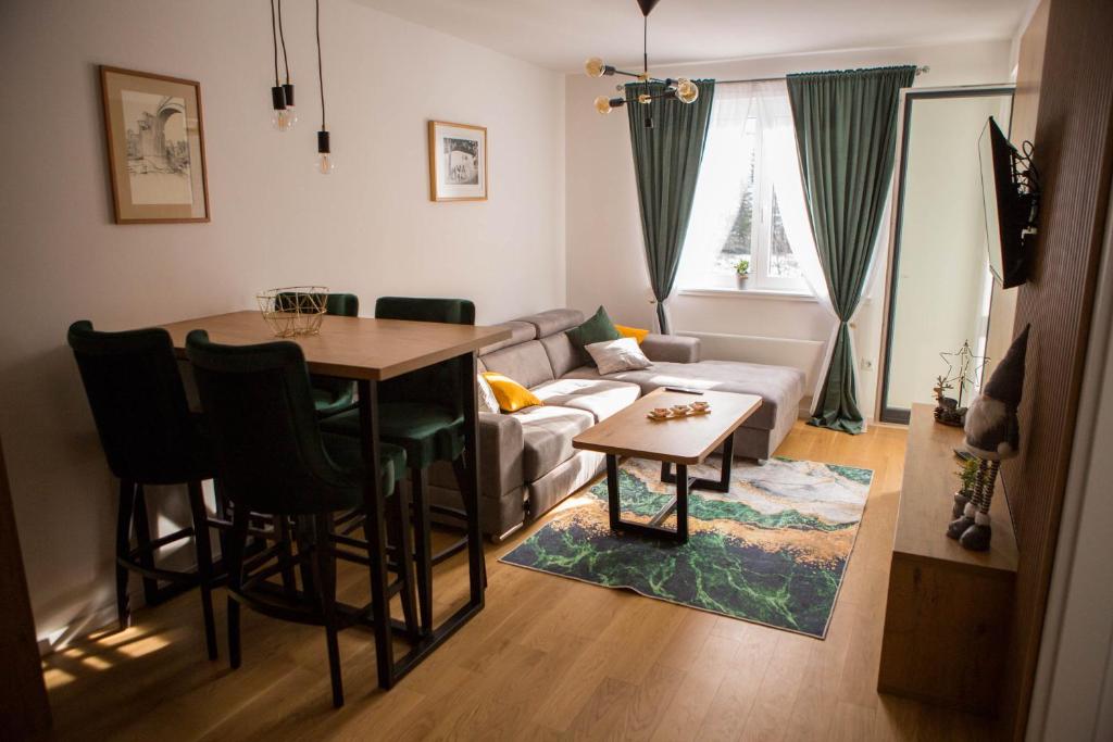 a living room with a table and a couch at Apartman Tanja Jahorina in Jahorina