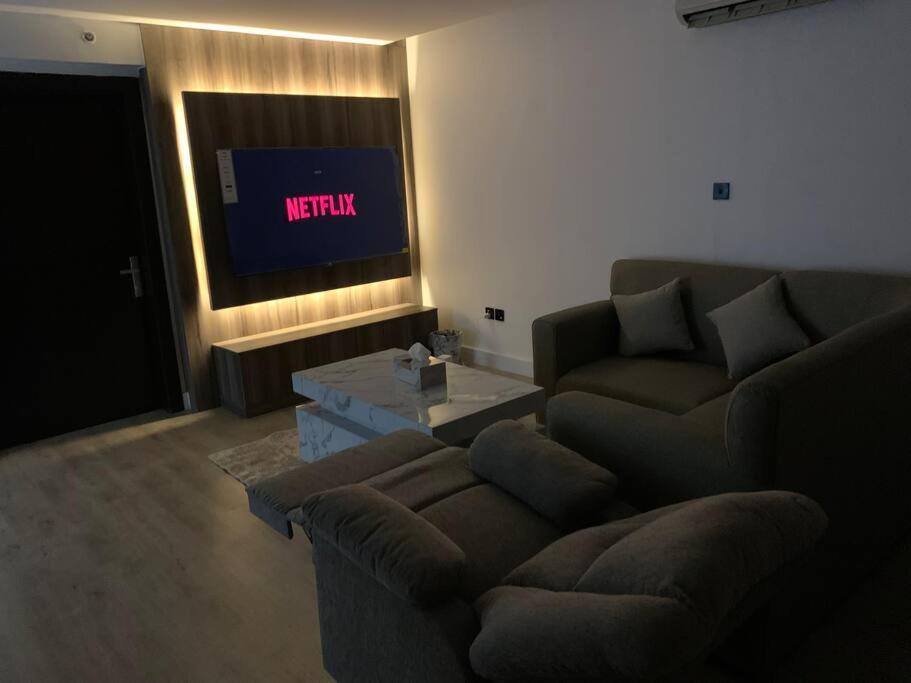 Down Town Appartment w/King bed في الرياض: غرفة معيشة بها أريكة وتلفزيون