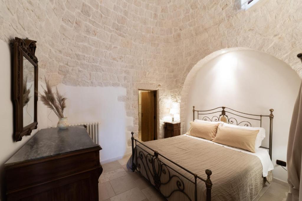 une chambre avec un lit, un miroir et une commode dans l'établissement Trulli Angela, à Locorotondo 55 autres photos
