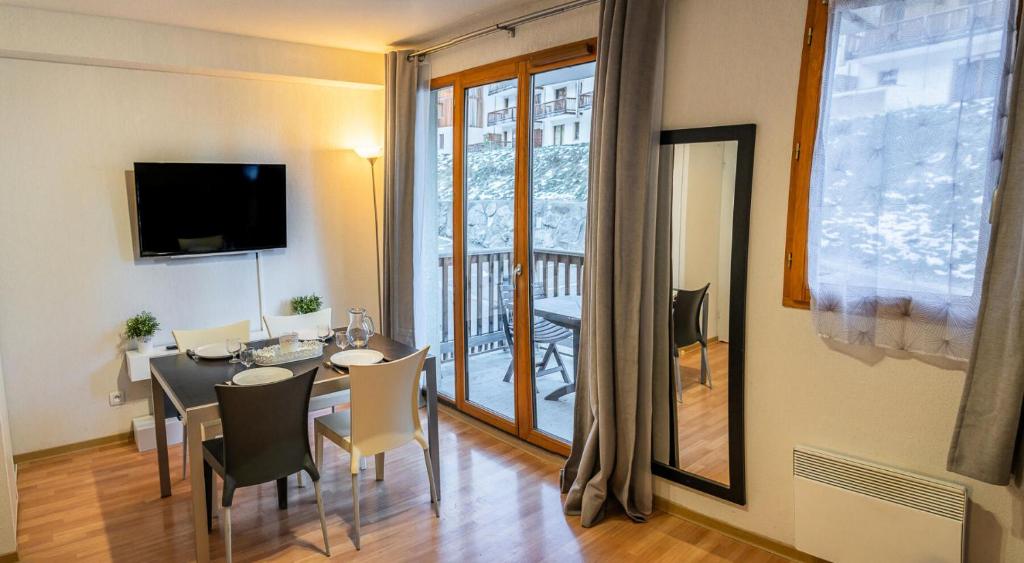 une salle à manger avec une table et des chaises et un balcon dans l'établissement Résidence Les Terrasses Du Soleil D'or - Appartement calme au pied des pistes MAE-6434, aux Orres