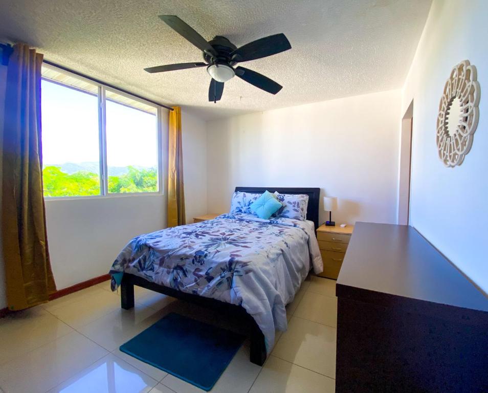 1 dormitorio con 1 cama y ventilador de techo en Penthouse Apartment with Spectacular Pool and Mountain Views!, en Jacó