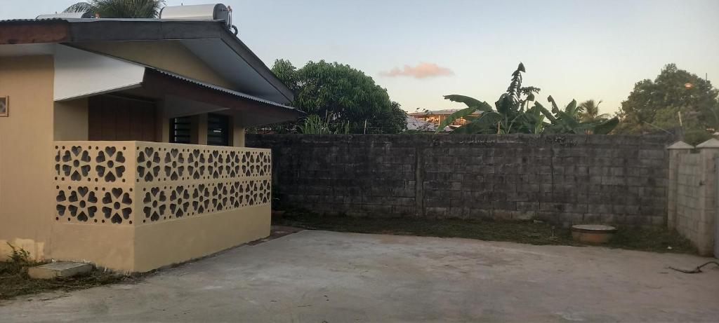 una casa con una pared de retención y una valla en Chez Nana, en Cayenne