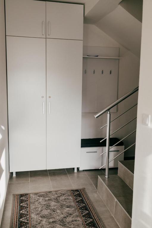 a room with white cabinets and a staircase at Deutsche Willa in Sutomore
