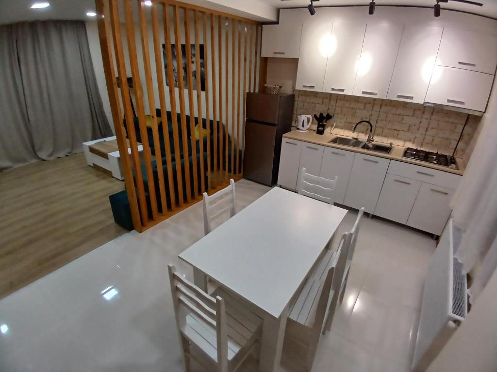 a kitchen with white cabinets and a table and chairs at Mountain view cotteges in Tsemi