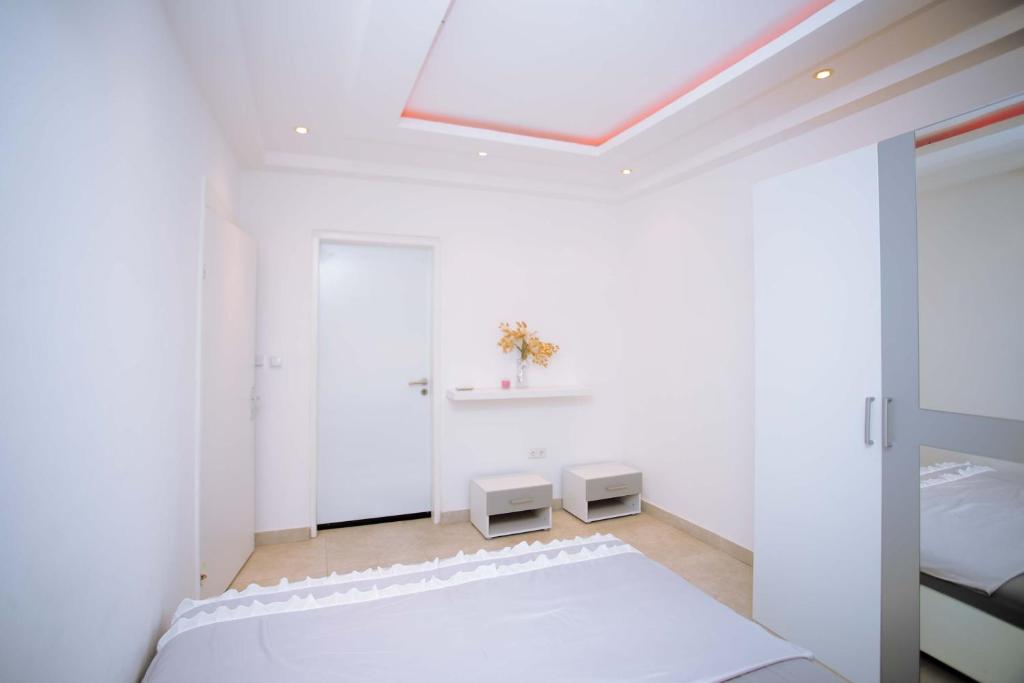 a white bedroom with a bed and a skylight at JQ Apartments Prime in Accra