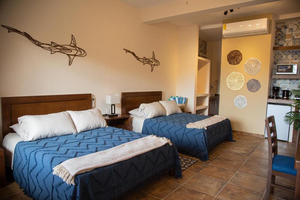 a hotel room with two beds and a kitchen at Estancia 105 in La Paz