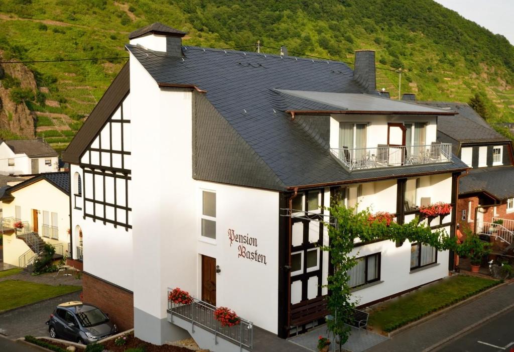 a white house with a black roof at Pension Basten in Ellenz-Poltersdorf