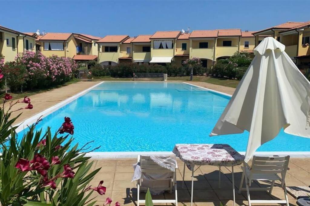 バデージにあるAppartement Baia delle Mimose i6の大型スイミングプール(パラソル、テーブル付)