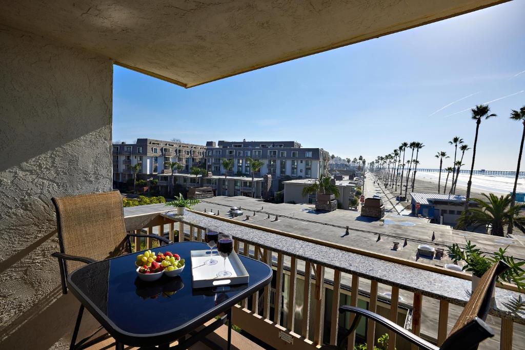 a table with a bowl of fruit on a balcony at Oceanfront condo at North Coast Village in Oceanside