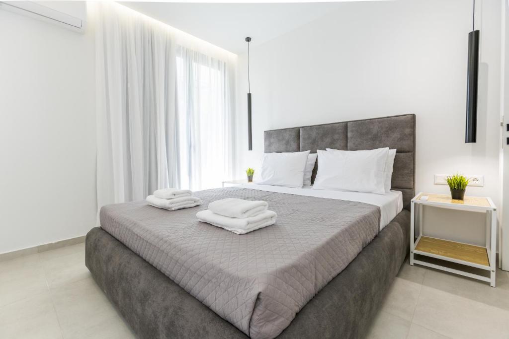 a bedroom with a large bed with towels on it at Varkiza Luxury Suites by Raise in Vari