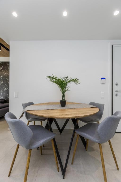 a dining room table with two chairs and a potted plant at Varkiza Luxury Suites by Raise in Vari