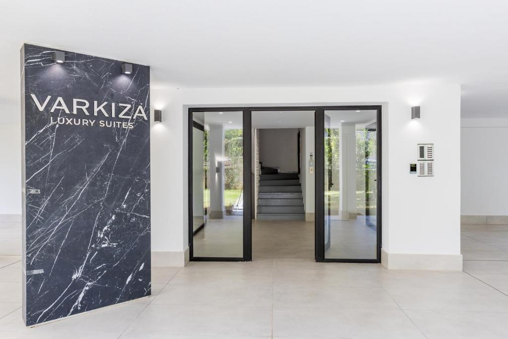 a lobby of a building with a black marble wall at Varkiza Luxury Suites by Raise in Vari