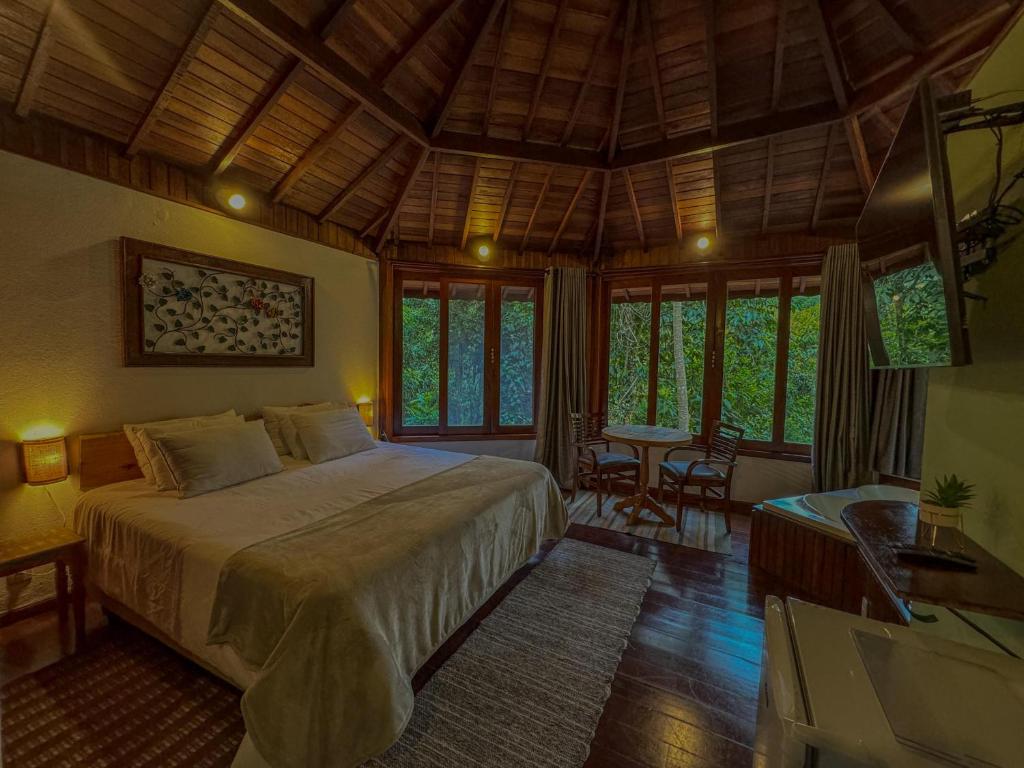 um quarto com uma cama num quarto com janelas em Pousada Recanto do Escorrega em Viscode de Mauá