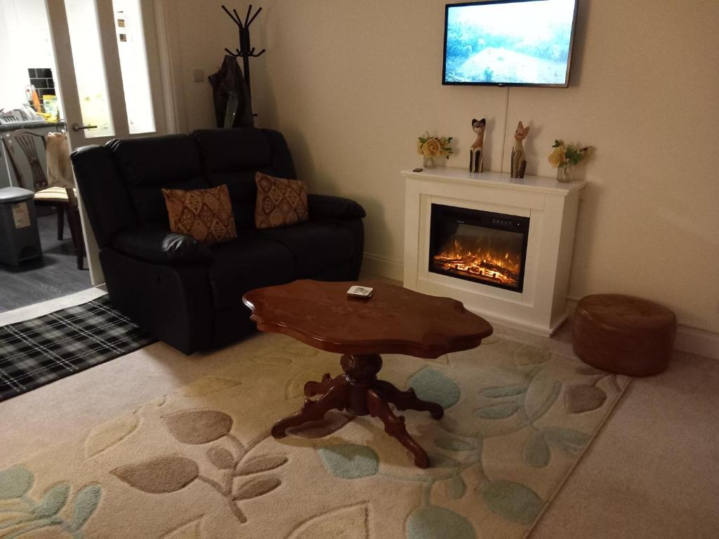 a living room with a table and a fireplace at Couple's Retreat-West Kilbride in Seamill