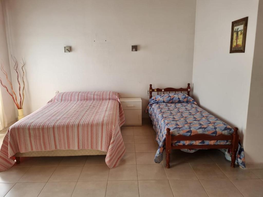 Un dormitorio con 2 camas y una silla. en Monoambiente Gualeguaychú en Gualeguaychú