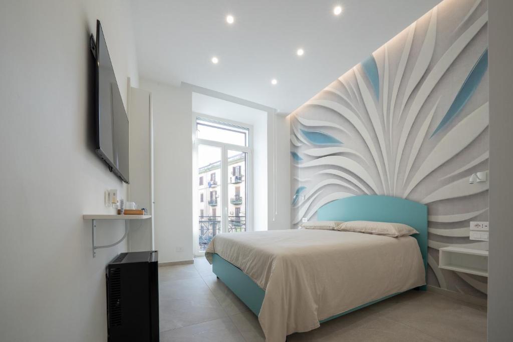 ナポリにあるB&B Corso Garibaldi 165のベッドルーム1室(壁に絵画が描かれたベッド1台付)