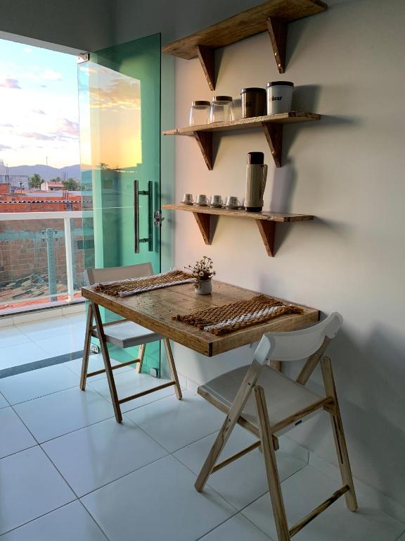 un tavolo e una sedia in una stanza con finestra di Hospedagem em Frecheirinha - Apê Sabiá 