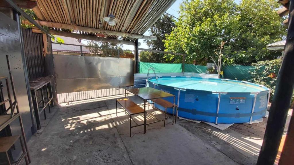 un patio con bañera de hidromasaje, mesa y sillas en Alquilo Casa, 2 Dormitorios y 1 Baño en Maipú