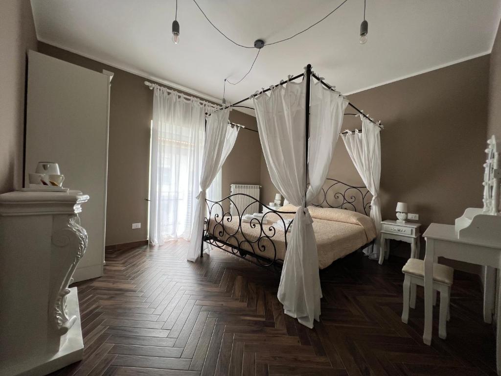 a bedroom with a canopy bed with white curtains at Casa Del Caval Bianco in Venaria Reale