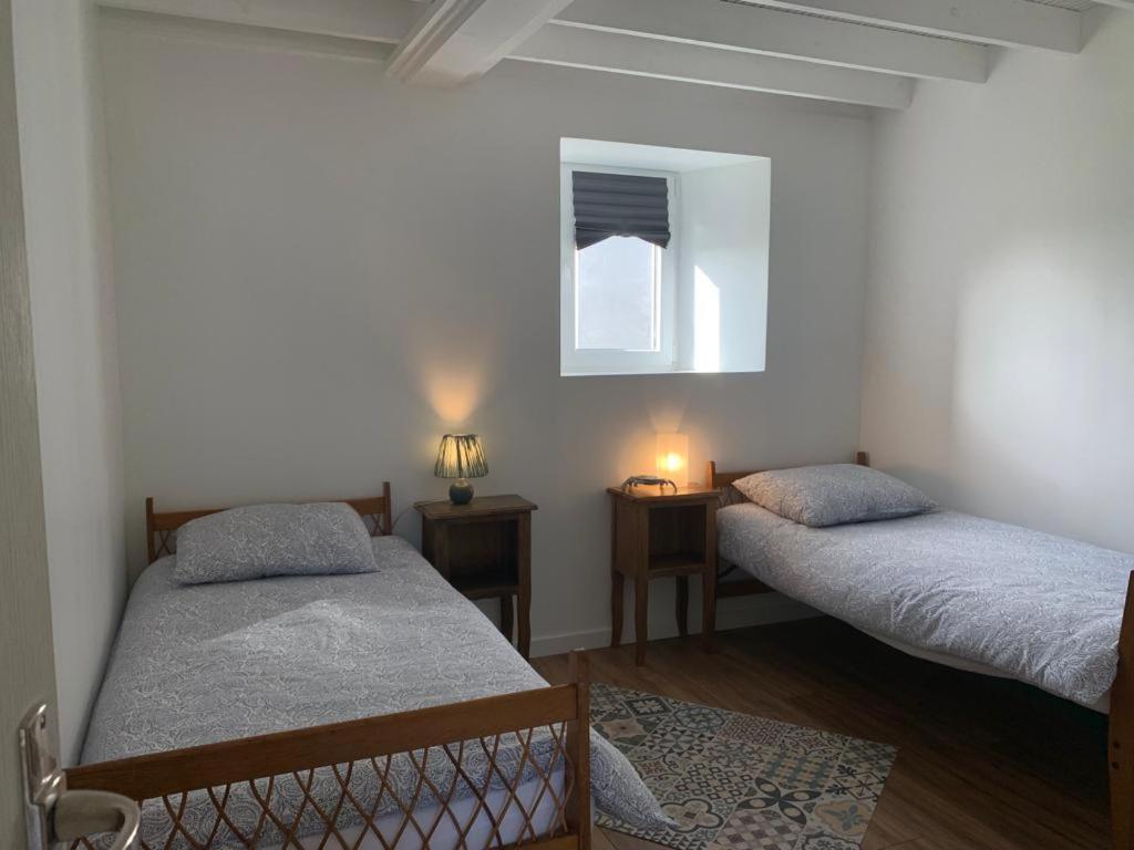1 dormitorio con 2 camas y ventana en Gîte 3 chambres en bord de Rance en La Ville-ès-Nonais