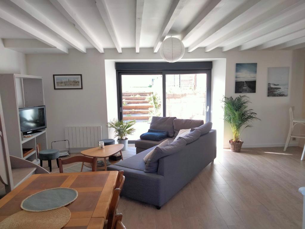 un salon avec un canapé et une table dans l'établissement Gîte 3 chambres en bord de Rance, à La Ville-ès-Nonais