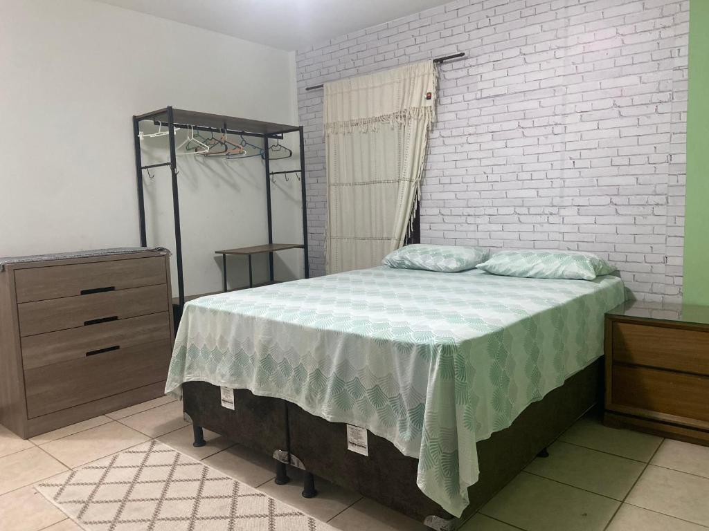 a bedroom with a bed and a brick wall at Casa próximo a Guaramiranga in Guaramiranga