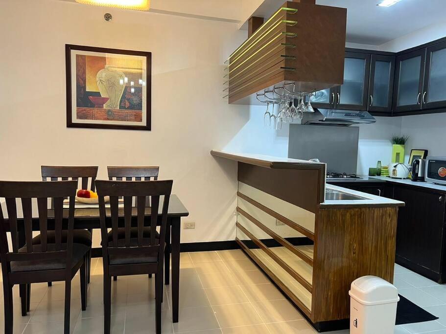 a kitchen with a table and chairs in a kitchen at Elegant Cozy 2BR Near The Airport in Manila