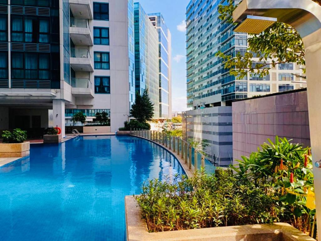 a swimming pool in a building with tall buildings at Luxury 2BR with Balcony Suite 25 - Pool, City View in Manila
