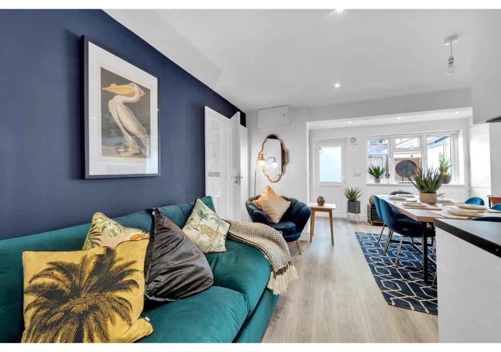 uma sala de estar com um sofá verde e uma mesa em Modern Deluxe 3 Bedroom Flat em Ascot