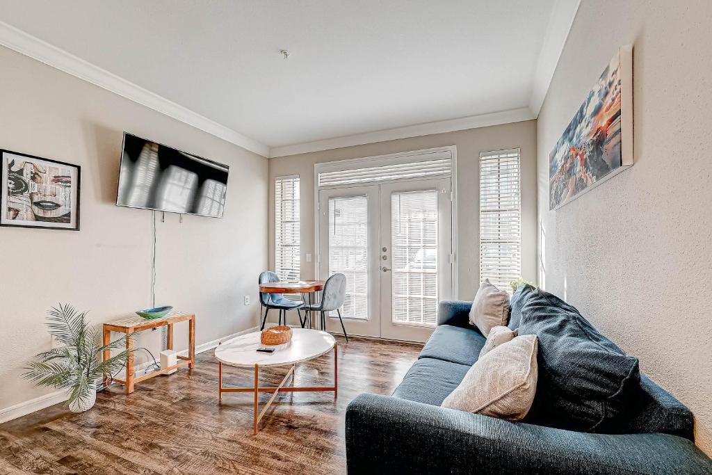 a living room with a blue couch and a table at Modern Apartment in Downton Houston in Houston