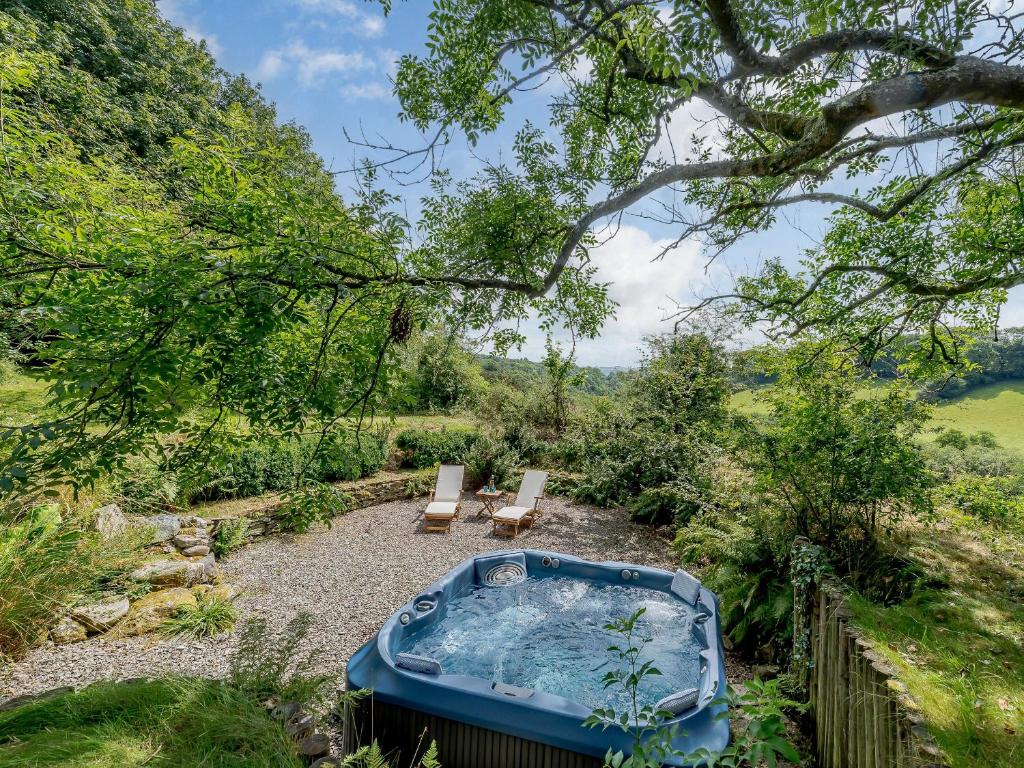 a hot tub and two chairs in a yard at Glanceri in Sarnau
