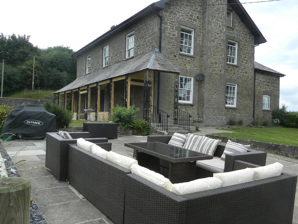 een gebouw met een tafel en stoelen ervoor bij Llansantffraed House in Llansaintfraed in Elvel