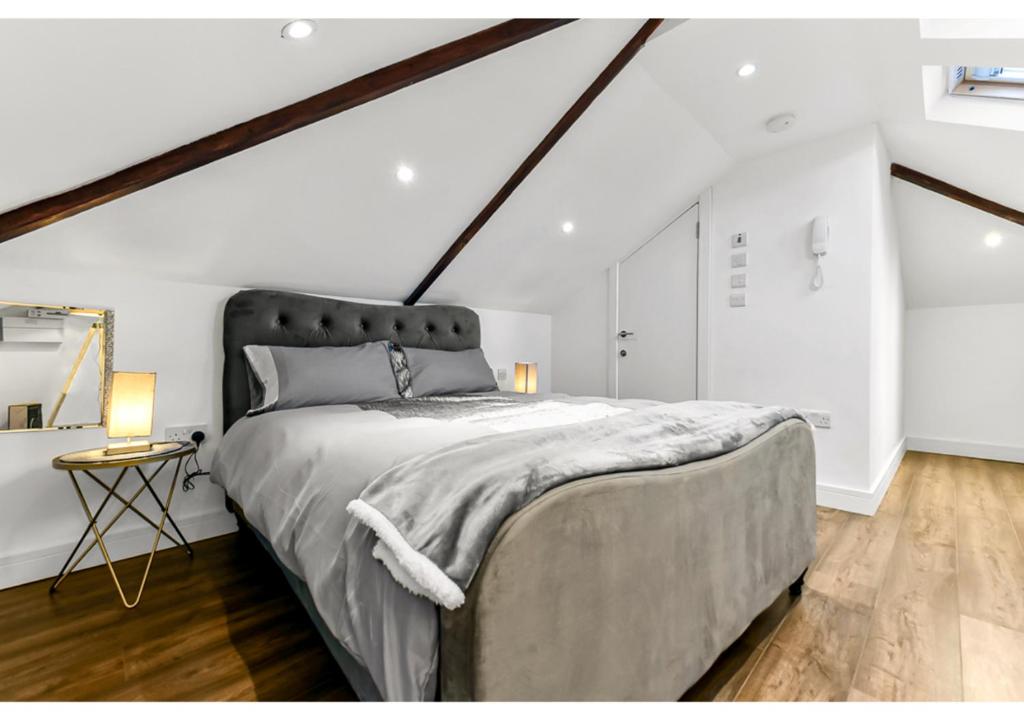 a bedroom with a large bed in a attic at Sleek and Modern Studio with Minimalist Vibe in Chelmsford