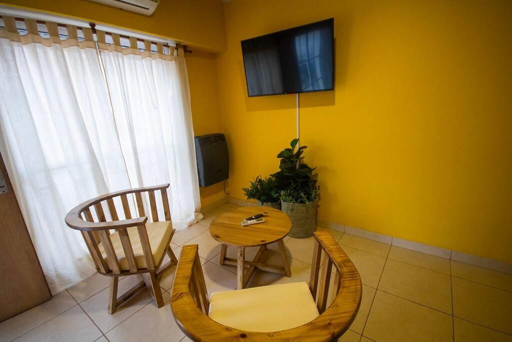 un soggiorno con tavolo, sedie e TV di Cómodo y Bien Ubicado! a Bahía Blanca