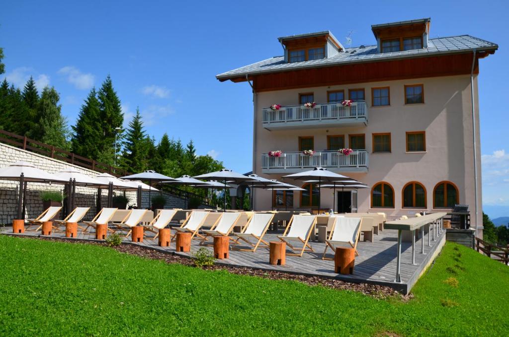 a building with a bunch of chairs and umbrellas at Hotel Norge in Norge