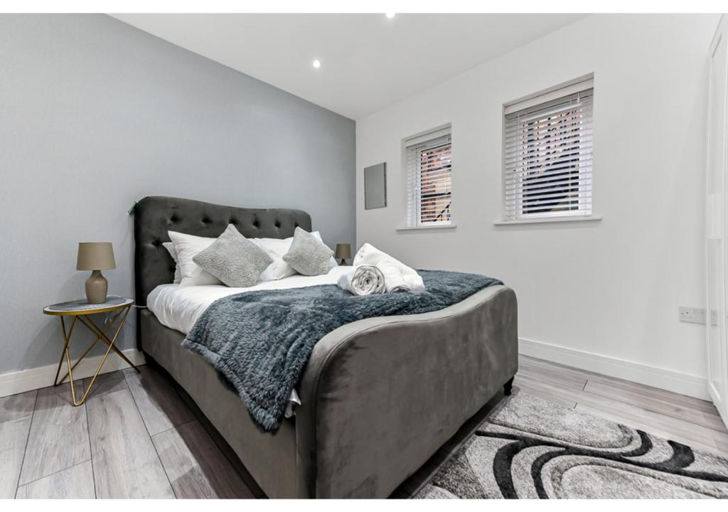 een slaapkamer met een groot bed met witte muren bij Chic 1BD Apartment in Chelmsford in Chelmsford