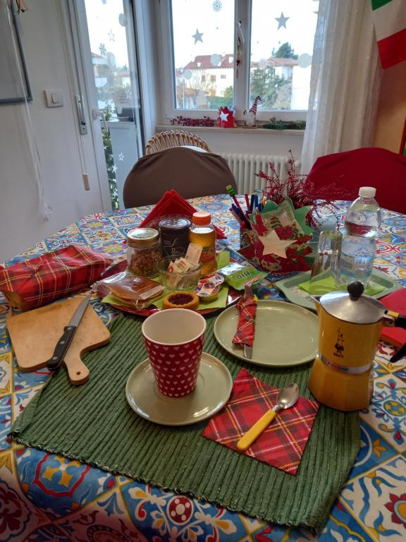 a table with plates and utensils on it at STANZA ORO bagno con doccia idromassaggio in Udine