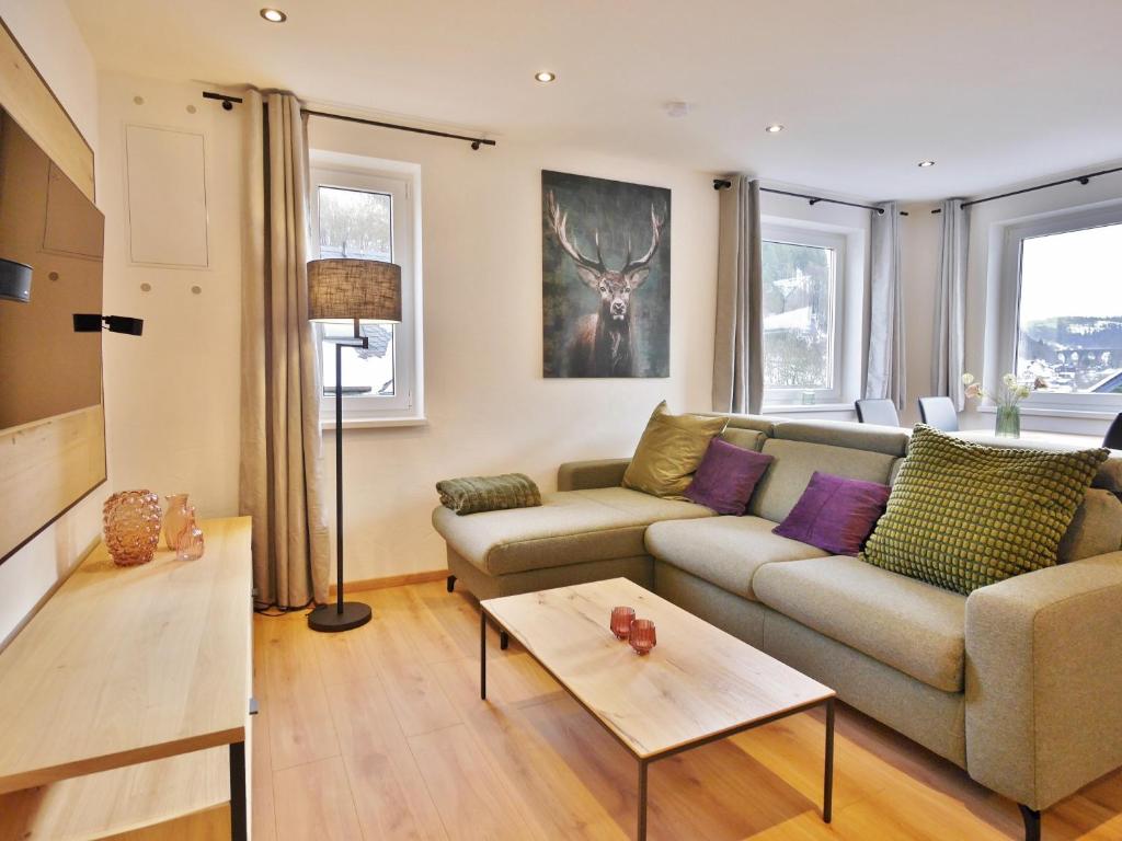 uma sala de estar com um sofá e uma mesa em Ferienwohnung Bergzauber 2 (inkl. MeineCardPlus) em Willingen