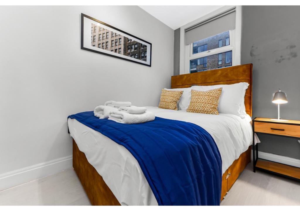 a bedroom with a bed with a blue blanket at Captivating 2 BD Flat in London in London