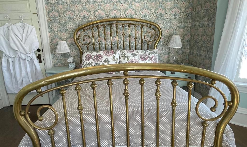 uma cama num quarto com uma estrutura de cama em The Captain's House heritage bed & breakfast em Midland