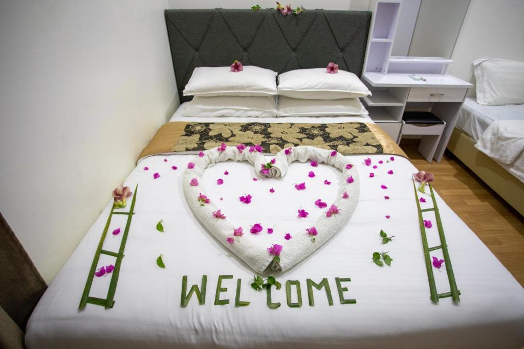Una cama con un corazón y una señal de bienvenida. en iHaven Thulusdhoo en Thulusdhoo