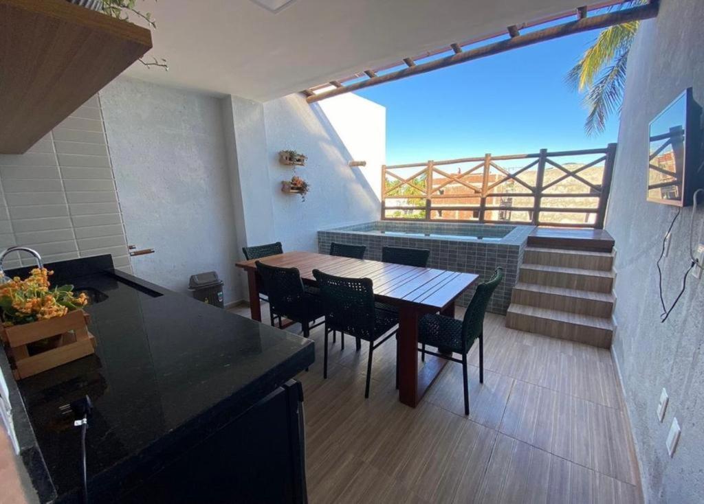 eine Küche mit einem Tisch und Stühlen auf dem Balkon in der Unterkunft VILA CORALLI CASA 05 in Passo de Camarajibe