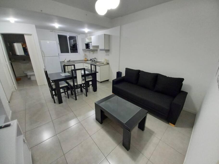 sala de estar con sofá negro y mesa en Dos ambientes con cochera La Boca/ San Telmo en Buenos Aires