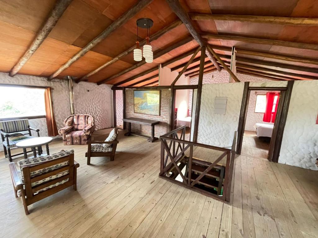 sala de estar con suelo de madera, sofá y mesa en Casa grande los tatas, en Maldonado