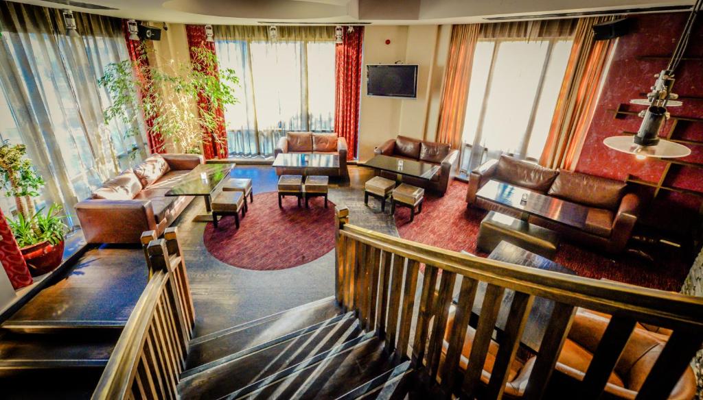 a large living room with leather furniture and windows at Osprey Hotel in Naas