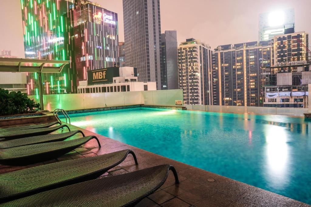a swimming pool on the roof of a building with chairs at 400m to KLCC Bukit Bintang Pavillion KLCC LRT walking distance Lot 163 Zenglo in Kuala Lumpur
