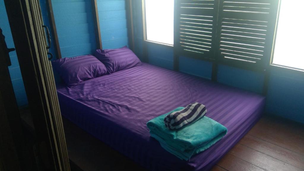 a purple bed in a room with a window at Crazy Monkey in Trat