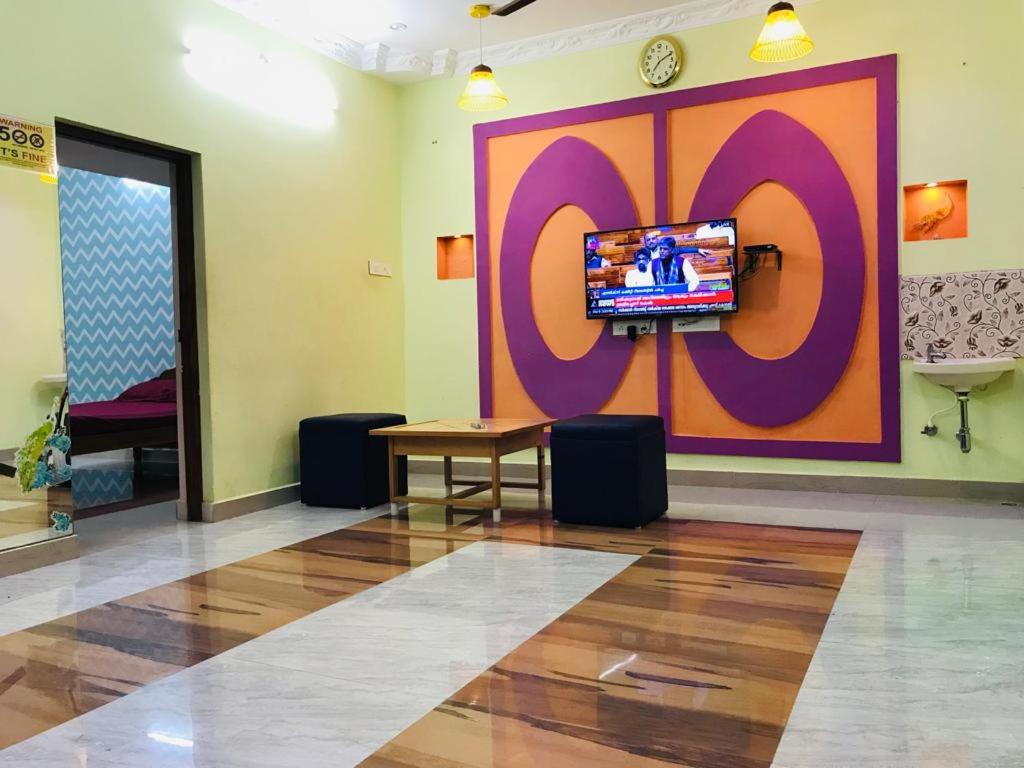 a room with a large wall with a tv on it at ECO VILLA in Pondicherry