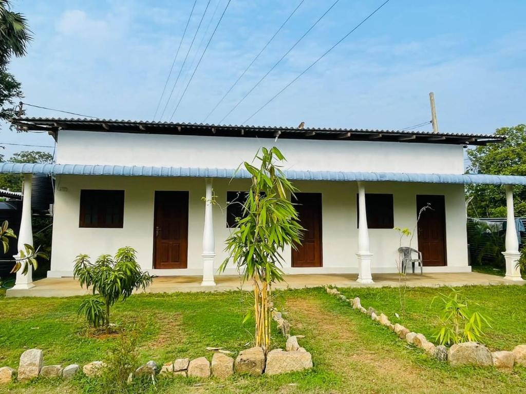 Biały dom z palmą przed nim w obiekcie JM resort w mieście Trikunamalaja